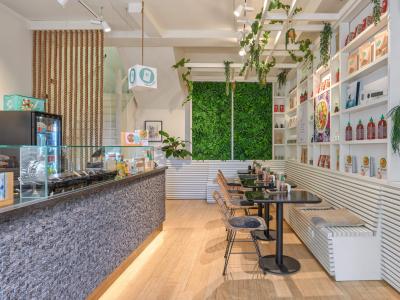 Interieur van een moderne poké bowl-winkel met een frisse inrichting en zitgedeelte.