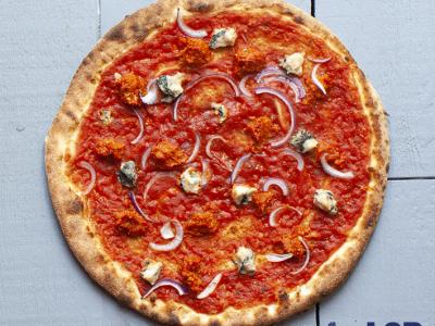 Plant-based pizza met tomatensaus, rode ui en blauwe kaas op een houten ondergrond met De Pizzabakkers LAB-logo.