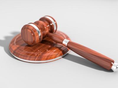 Houten hamer en klankbord symbool voor juridische bescherming van franchisenemers.