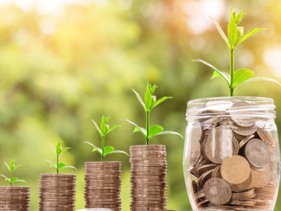 Stapel muntgeld en een pot vol munten met groeiende planten symboliseren financieel rendement.