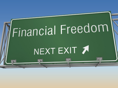 Groen verkeersbord met de tekst Financial Freedom Next Exit tegen een blauwe hemel.