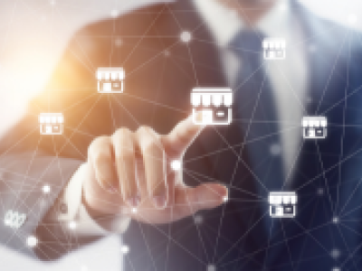 Man in pak wijst naar digitaal netwerk van franchise-icoontjes, symboliseert connectie en financiële strategieën.