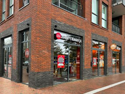 Gevel van Johnny's Burger Co. en O'Tacos met openstaande vacatures in een bakstenen gebouw in Zwolle.