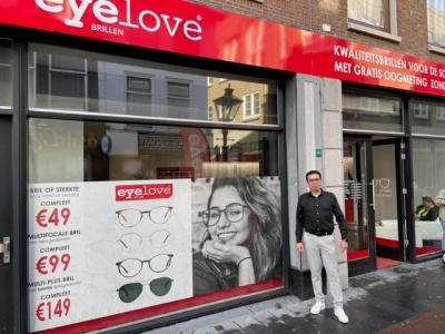 Eyelove winkel in Leiden met groot uithangbord en reclameposters, naast een persoon bij de ingang.
