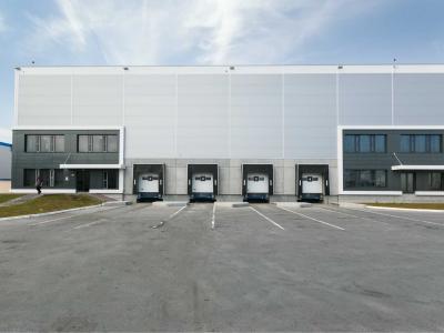 Prefab opslaghal met meerdere laadperrons en bijgebouwen, bevordert snelle en kostenefficiënte bouw voor franchisers.