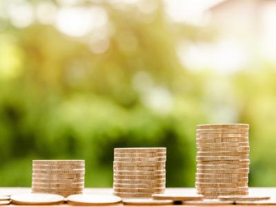 Drie stapels munten in oplopende hoogte, symbool voor financiële groei of budgetbeheer.