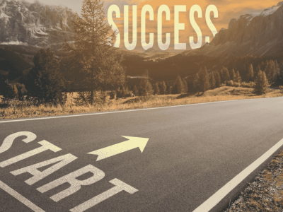 Open weg met een pijl en het woord START op het asfalt, leidend naar SUCCESS tegen een bergachtige achtergrond.