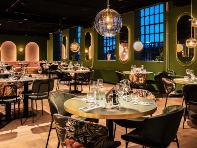 Stijlvol en sfeervol restaurantinterieur met gedekte tafels en stijlvolle verlichting.