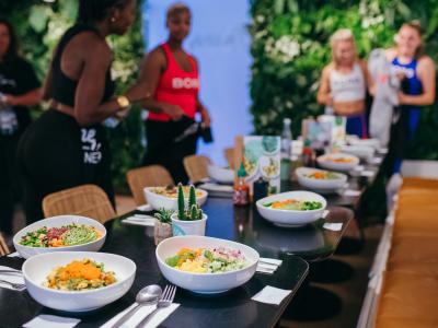 Pokébowls op tafel in een modern restaurant met jong publiek op de achtergrond.
