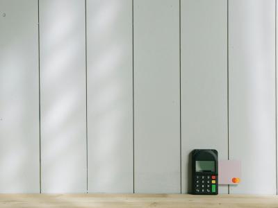 Een betaalterminal op een houten oppervlak met een ingevoegde betaalkaart.