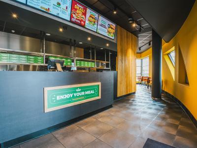 Interieur van Burger Business in Almere met een modern bestelgedeelte en groen-witte decoratie.