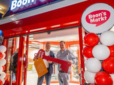 Twee mannen houden een grote symbolische sleutel vast bij de feestelijke opening van Boon's Markt in Vreeswijk.