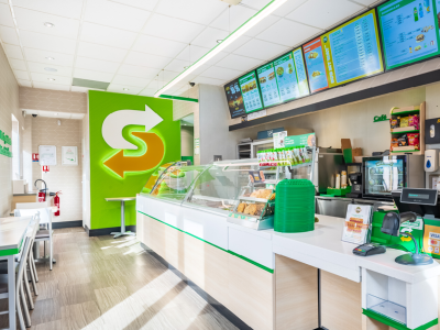 Interieur van een nieuw Subway restaurant met toonbank, menuborden en zitgedeelte aan het Betaplein in Leiden.