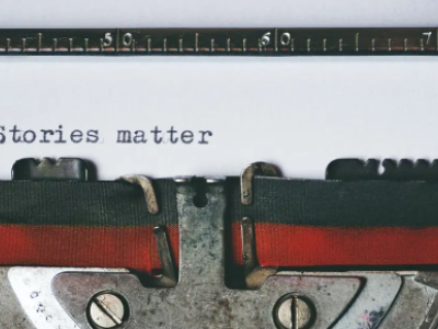 Een typemachine typt de tekst Stories matter op een vel papier.