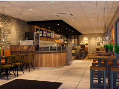 Interieur van een moderne restaurantinrichting met houten tafels, stoelen en een stenen accentmuur.