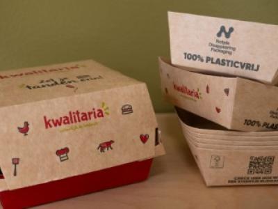 Kartonnen verpakkingen van Kwalitaria met de tekst 100% plasticvrij op een tafel.