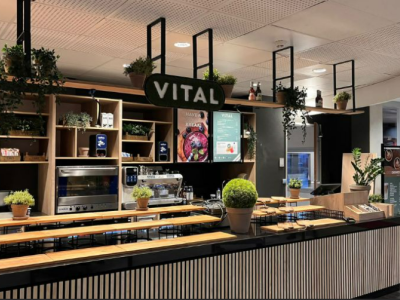 Interieur van een moderne VITAL eet- en drinkgelegenheid met planten en een uitnodigende balie.