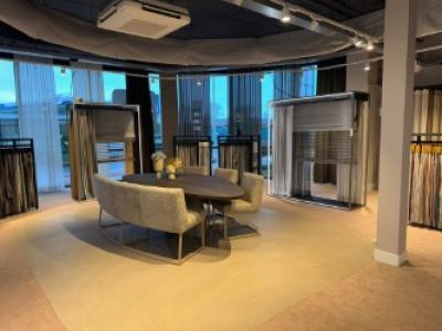 Interieur van de nieuwe Aanhuis.nl XL-showroom in Wormerveer met een moderne tafel op een lichte vloer.