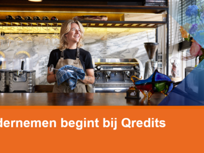 Een lachende barista staat in een koffiebar, klaar om gasten te bedienen, met kopjes en apparatuur op de achtergrond.