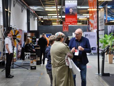 Bezoekers en standhouders in gesprek op de Franchise+ Beurs 2026, met verschillende bedrijfsstands op de achtergrond.