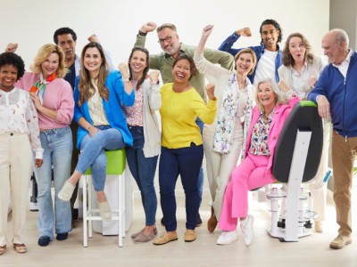 Een diverse groep mensen viert samen een succesvol moment in een lichte, moderne fitnessruimte.