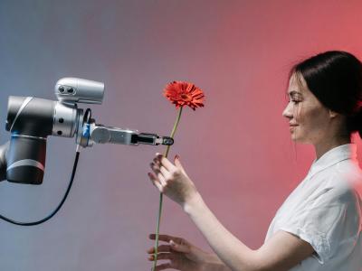 Vrouw neemt bloem aan van AI robot