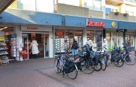 Winkelpand van Bruna Zevenaar met passerende klanten en geparkeerde fietsen voor de deur.